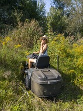 Woman driving lawn mower