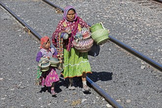 Mexican woman with child selling souvenirs to tourists on the tourist train of the Chepe Express