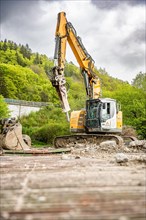 Yellow Liebherr crawler excavator recycling on demolition site