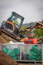Black Yanmar Mini tracked excavator during earthworks for house construction on building site