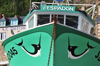Bow of green fishing boat decorated with swordfish in the harbour at Erquy