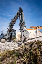 Black Liebherr crawler excavator with spreader recycling on demolition site