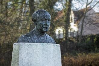 Bust of the Flemish poet Guido Gezelle in garden at birthplace in the city Bruges
