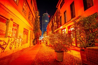 Restaurant and pub alleyway Wagnergasse in Jena at night with the Jentower in the background