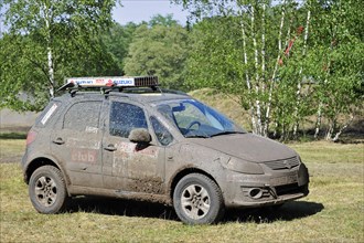 Suzuki SX4 four-wheel drive off-road vehicle covered in mud after rally racing