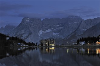 The mountain range Gruppo del Sorapis and hotels at night along lake Lago di Misurina in Auronzo di Cadore