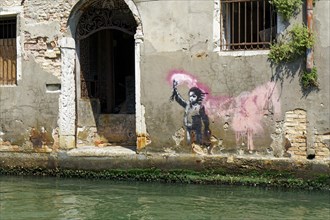 Banksy graffito on a canal in the Dorsoduro district of Venice