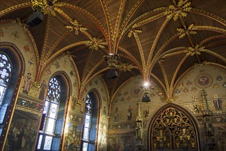 Interior of the city hall of Bruges showing the Gothic hall with polychrome vault and 19th century murals