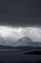 Black stormy sky and downpour during rain storm over desolate wilderness of Coigach