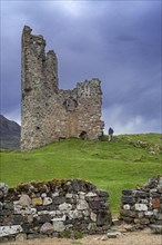 Tourist visiting 16th century Ardvreck Castle ruin at Loch Assynt in the Scottish Highlands