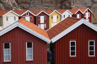 Colourful traditional fishing huts and boathouses along wooden pier at Smoegen