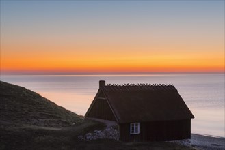 Fishing hut at sunrise in summer along the Baltic Sea coast at Havaeng