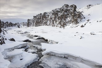 Oexara river running throught the Almannagja Canyon in the snow in winter