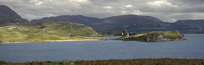 Calda House and the 16th century Ardvreck Castle ruins at Loch Assynt in the Highlands at sunset