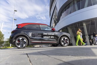 A new Smart brand vehicle in front of the Mercedes Museum in Stuttgart