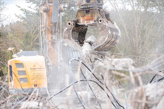 Yellow Liebherr crawler excavator recycling on demolition site