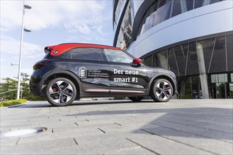 A new Smart brand vehicle in front of the Mercedes Museum in Stuttgart