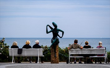 Passers-by look at the Baltic Sea in Timmendorf on the promenade. Hanseatic City of Luebeck
