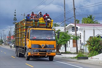 Workers on top of heavily laden truck in the village Soesdyke