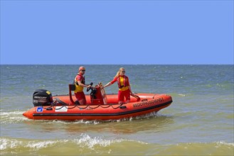 Young Belgian lifeguards in inflatable rescue boat patrolling along the North Sea coast in summer at Koksijde