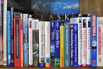 Collection of travel guides about worlwide holiday destinations on a bookshelf