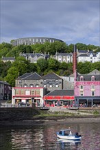 Oban Distillery and McCaig's Tower on Battery Hill overlooking the city Oban
