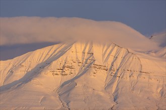 Snow covered mountain peak at sunset at Billefjorden