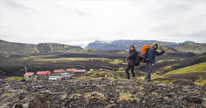 A couple with backpacks leaving the shelter of the 54 km trek from Landmannalaugar
