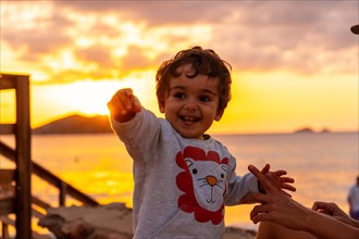 Boy laughing at sunset in Cala Comte beach on the island of Ibiza. Balearic