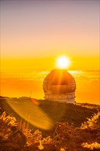 Astronomical Observatory of the Caldera de Taburiente in a beautiful orange sunset with the sun above