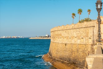 Walls and sea coast of the Baluarte de la Candelaria in the city of Cadiz. Andalusia