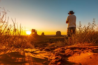 A lifestyle boy with a hat at dawn in Monument Valley