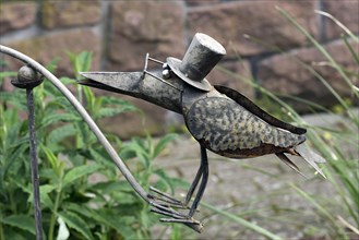 Raven as a tin figure in a garden