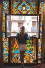 Young blonde caucasian woman in a white dress and denim jacket enjoying a beautiful medieval hotel in the town of Olite in Navarra. Spain