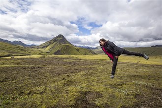A young girl on a green mountain on the 54 km trek from Landmannalaugar