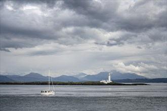 A sailing ship sails on Loch Linnhe past Lismore Lighthouse