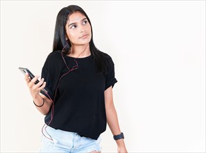 Portrait of beautiful girl listening to music with smartphone isolated. Happy latin gir listening to music with cell phone. Latin girl enjoying music with phone isolated