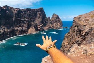 Hand of a young man with bracelets in Ponta de Sao Lourenco in summer