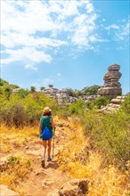 A young woman trekking in Torcal de Antequera on the green and yellow trail