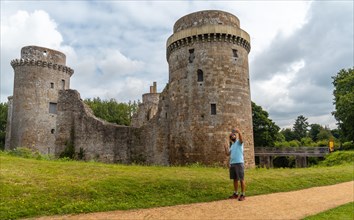 A young man visiting the walls of the medieval Hunaudaye Castle