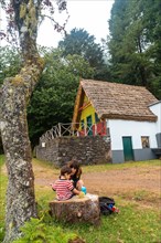 A family in the traditional Madeiran house like those of Santana in the forest of Caldeirao Verde
