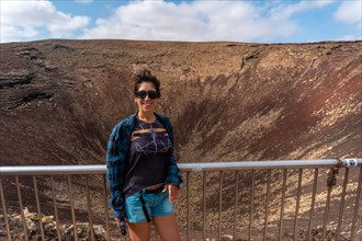 A young tourist visiting the Crater of the Calderon Hondo volcano near Corralejo