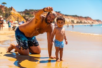 Father playing in the sand with son