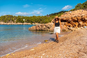 A young woman with a hat in Ibiza at Salada y Saladeta beach. Balearic