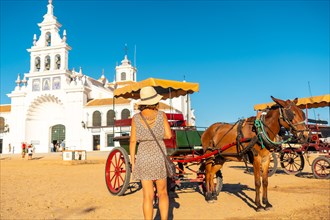 A tourist with horses and carriages in the Rocio sanctuary at the Rocio festival