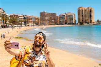 A young tourist taking a selfie at Playa del Cura in the coastal city of Torrevieja