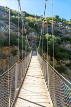 Wooden suspension bridges in the Loriguilla reservoir. Ruta de los Pantaneros in the town of Chulilla in the Valencian community. Spain