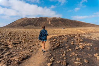 A young woman on the trail to the Crater of the Calderon Hondo volcano near Corralejo