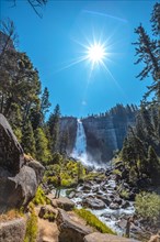 A brunette tourist with black T-shirt in Vernal Falls from the bottom looking at the waterfall. California