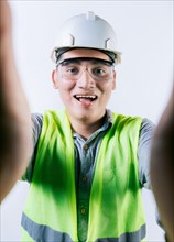 Cheerful builder engineer taking a selfie isolated. Engineer taking a selfie isolated. Smiling male engineer taking a selfie looking at camera